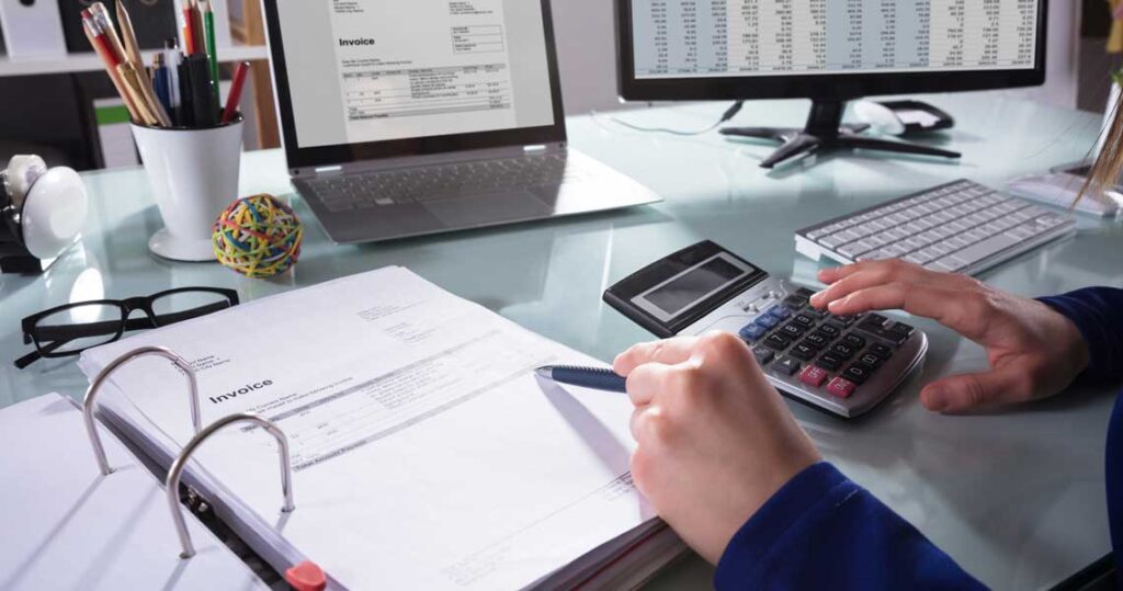 Tax consultant finding tax refunds on paperwork and calculator